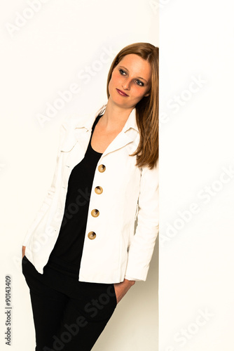 young woman leaning against awall photo