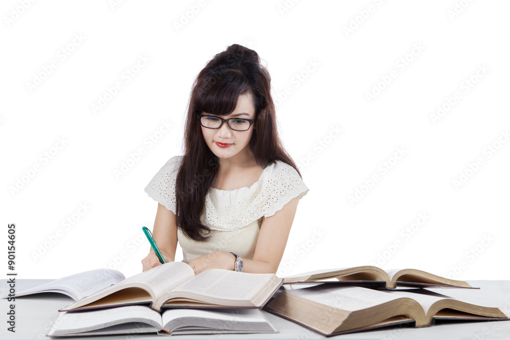 Student doing school task while writing on the book Student doing school task while writing on the book