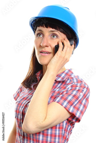 Builder woman in protective helmet talking on mobile phone