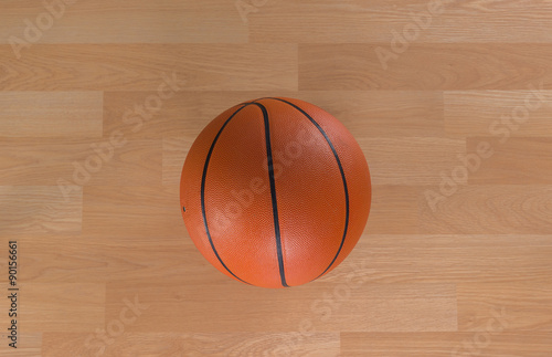 An official orange ball on a hardwood basketball court