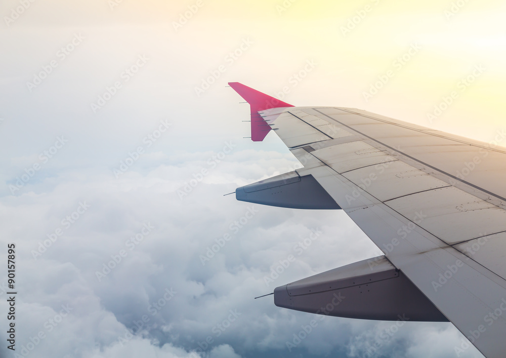 Wing of an airplane flying above the clouds Wing of an airplane flying above the clouds
