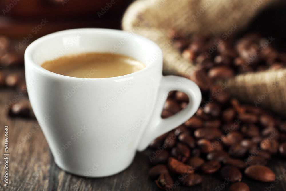 Cup of coffee with beans on table close up Cup of coffee with beans on table close up