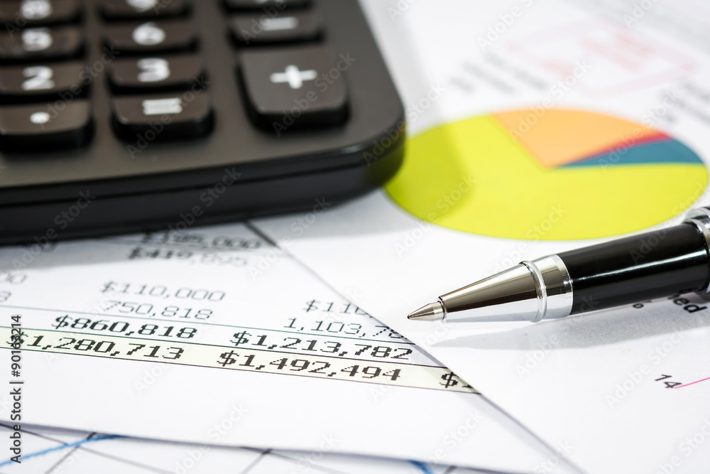 Black pen with financial report and calculator Black pen with financial report and calculator
