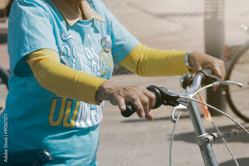 Udon Thani, Thailand, August 16, 2015: bikes for a cycling event at the mother biking together in the streets. Energize the Queen Mother. An elderly woman's hand on a bicycle, metro tone.
