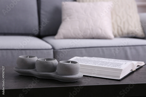Book and candlestick on table on Modern sofa  background © Africa Studio