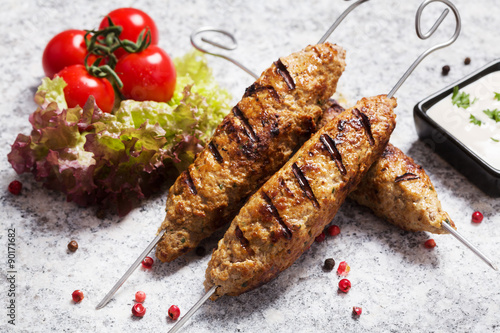 Barbecued kofta - kebeb with vegetables on a plate. photo