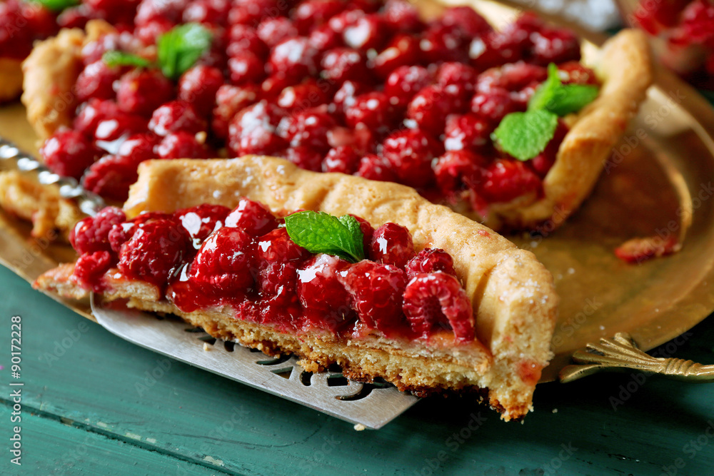 Piece of tart with raspberries on tray, close-up, on color wooden background Piece of tart with raspberries on tray, close-up, on color wooden background