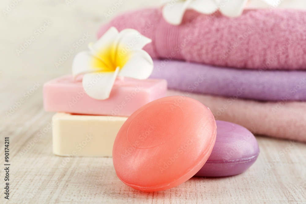 Bars of natural soap and colorful towels on light background Bars of natural soap and colorful towels on light background