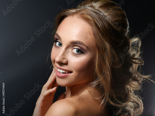 Beautiful woman with curly long hair on dark background