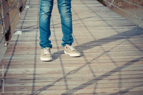 standing strong, abstract pose of a kid leg standing on a wood bridge with shadow lighting