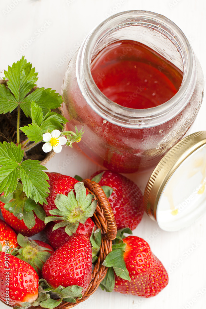 Basker of fresh strawberries and pot of honey Basker of fresh strawberries and pot of honey