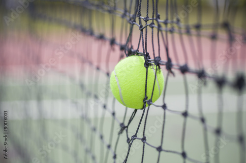 Tennis ball in net at tennis court © tatomm