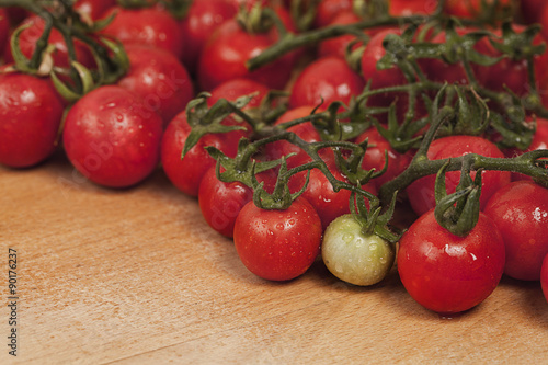 Fresh cherry tomatoes on wooden background