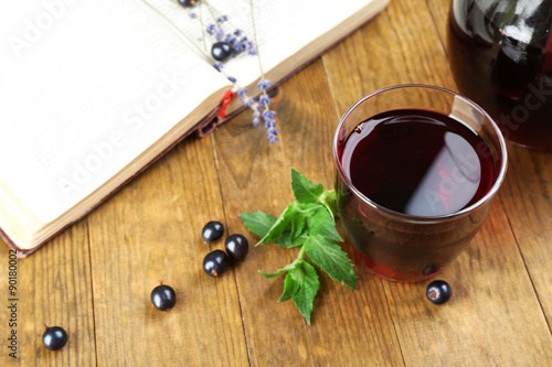 Fresh currant juice with berries and book on table close up