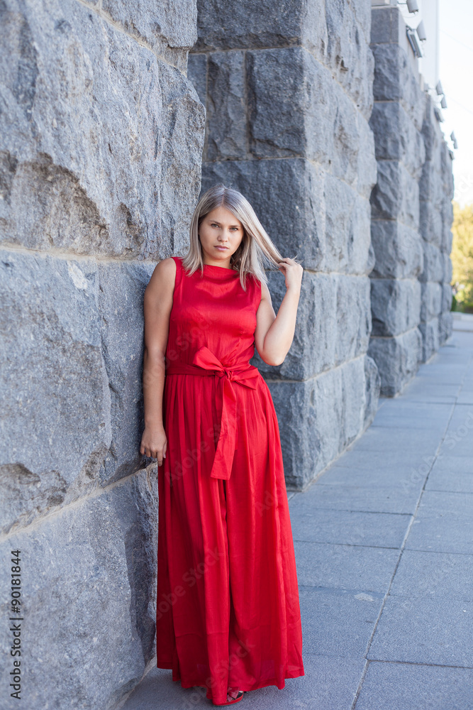 beautiful girl posing in a red evening dress in the park outdoor