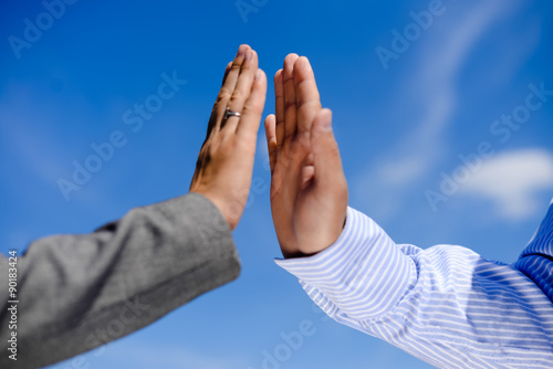 Business man and woman giving five, close up hands detail. Two