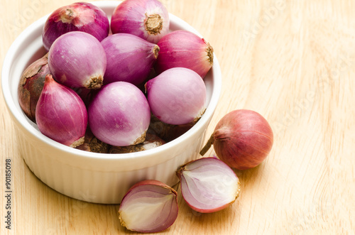 Shallots in the bowl on wooden background