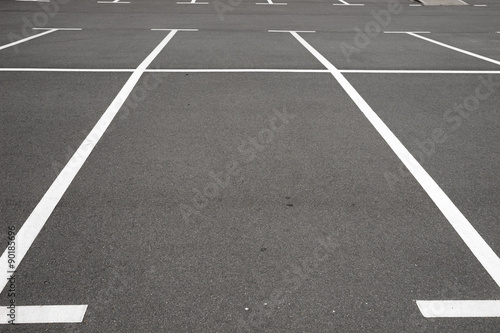 Leerer Parkplatz mit weißen Markierungslinien auf schwarzen Asphalt