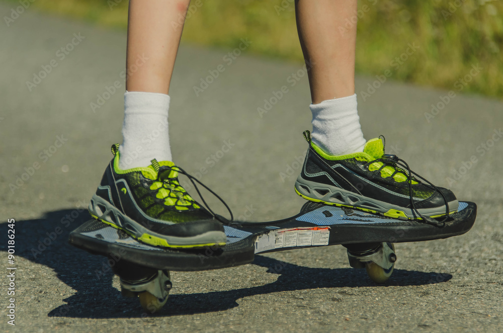 Fototapeta premium Legs in sneakers on a skateboard