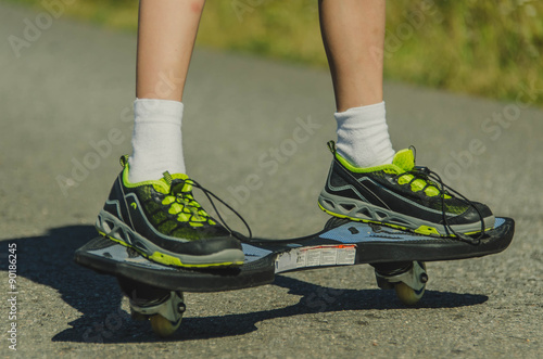 Fotografie Legs in sneakers on a skateboard