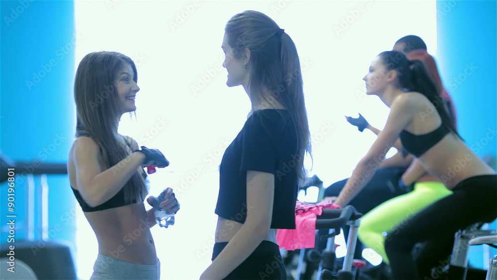 Athletic girls with sexy body opens water bottle and drink Athletic girls with sexy body opens water bottle and drink