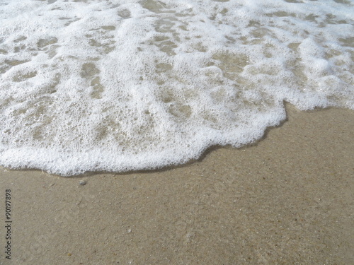 Auslaufende Welle auf Sandstrand