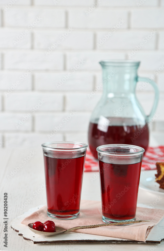 Sweet homemade cherry compote on table, on light background Sweet homemade cherry compote on table, on light background