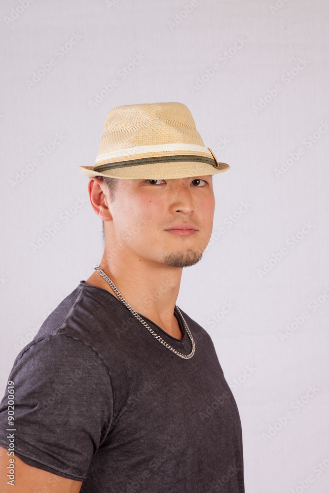 Handsome Asian man in hat, looking thoughtful Handsome Asian man in hat, looking thoughtful