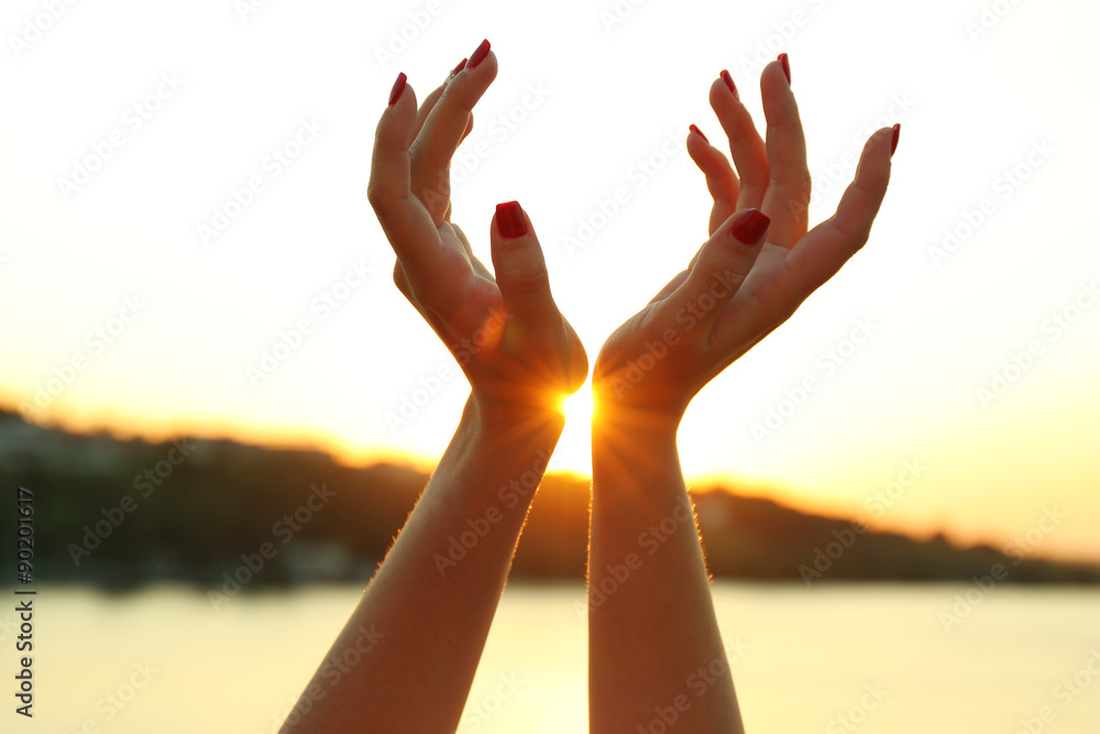 Female hands on sunny sky background Female hands on sunny sky background