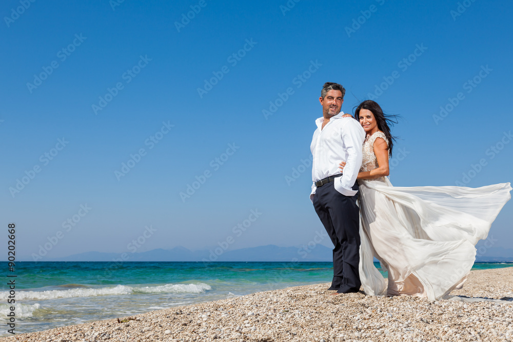 bride and groom, together in sunshine on a beautiful tropical be bride and groom, together in sunshine on a beautiful tropical be