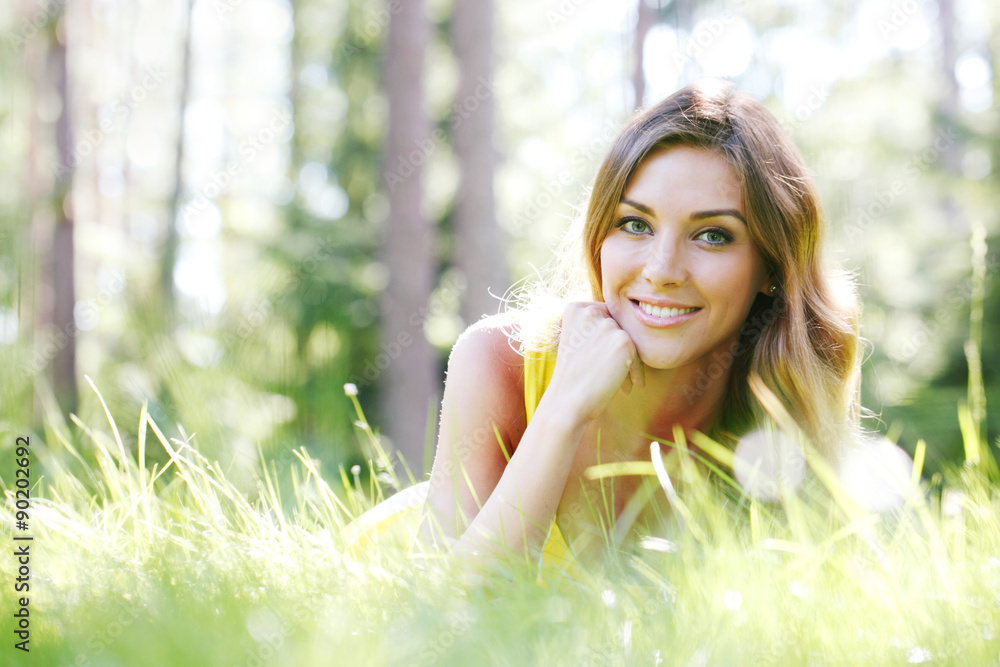 young woman in yellow dress lying on grass young woman in yellow dress lying on grass