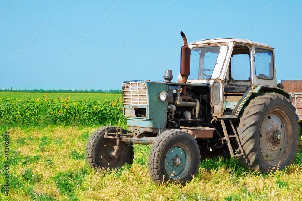 Tractor in field on blue sky background Tractor in field on blue sky background