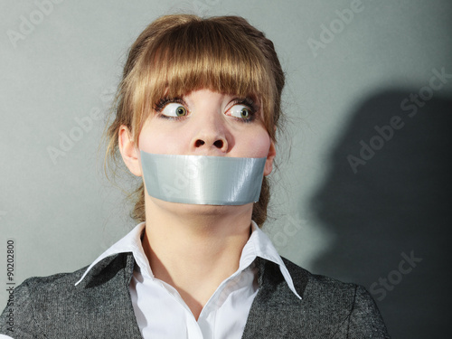 Fotografie Scared woman with mouth taped shut. Censorship.