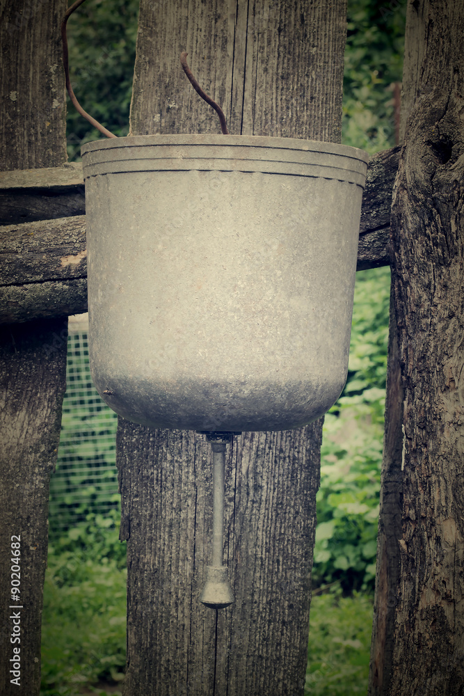 Fototapeta premium Old washbasin on the fence. Tinted photos