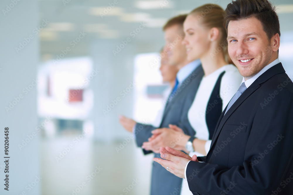 Smiling business people applauding a good presentation in the Smiling business people applauding a good presentation in the