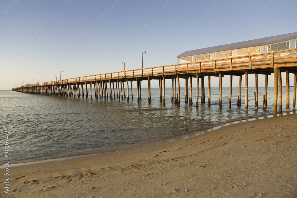 The sun setting on the pier and the Atlantic Ocean in Virginia Beach, Virginia
