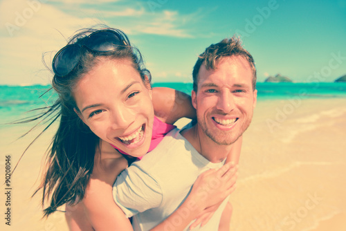 Happy Man Giving Piggyback Ride To Woman At Beach © Maridav