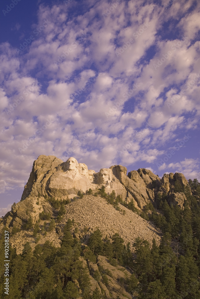 White puffy clouds behind Presidents George Washington, Thomas Jefferson, Teddy Roosevelt and Abraham Lincoln at Mount Rushmore National Memorial, South Dakota