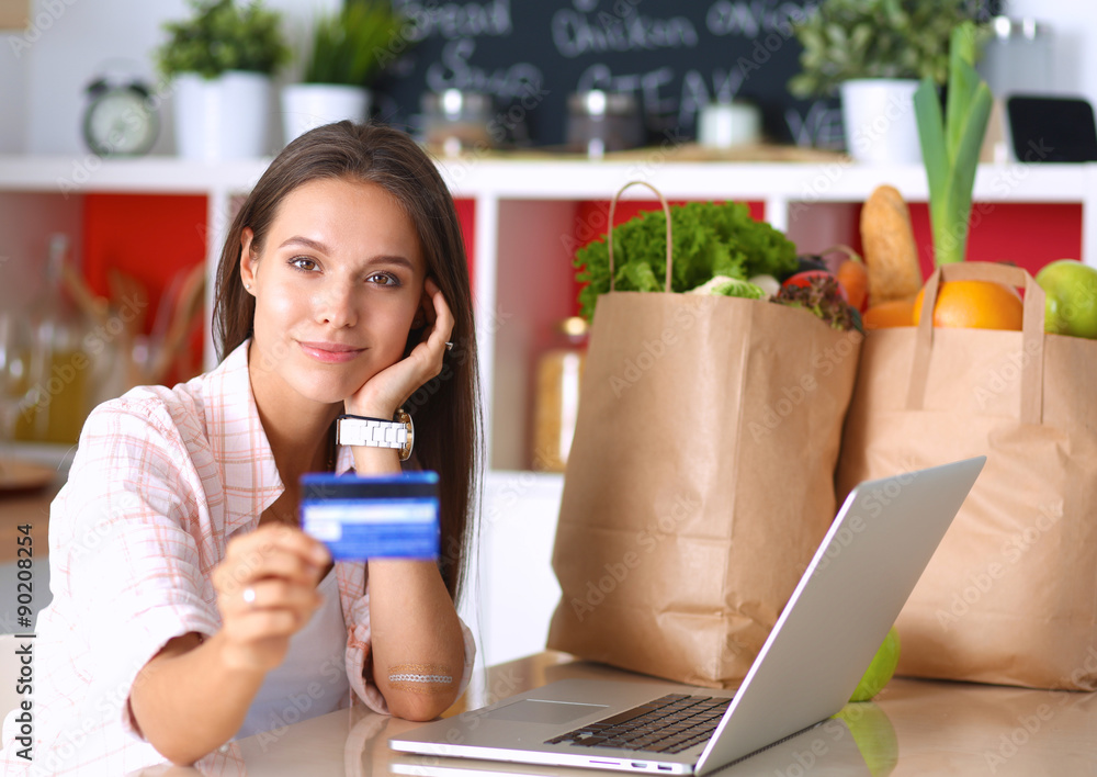 Smiling woman online shopping using tablet and credit card in Smiling woman online shopping using tablet and credit card in