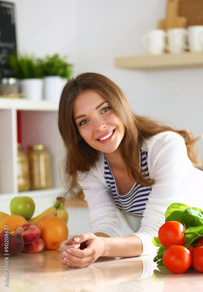 Young woman standing near desk in the kitchen
