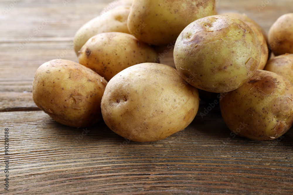 Young potatoes on wooden table close up Young potatoes on wooden table close up
