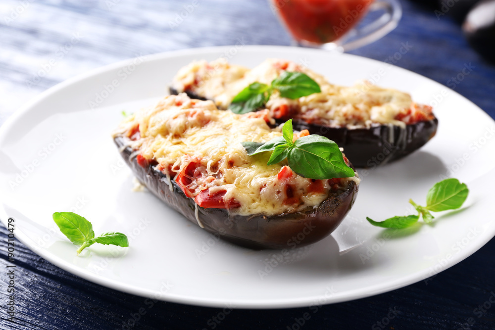 Dish of eggplant with cherry tomatoes and cheese in white plate on wooden table, closeup Dish of eggplant with cherry tomatoes and cheese in white plate on wooden table, closeup