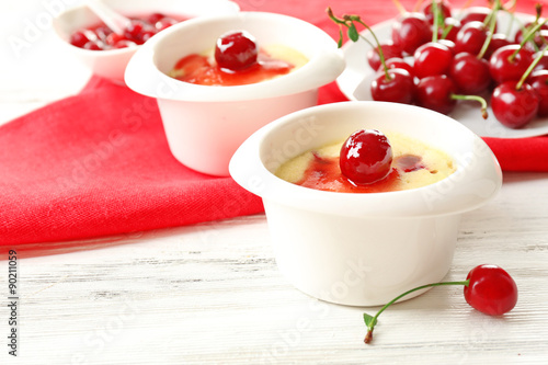 Tasty pudding with cherries on table close up