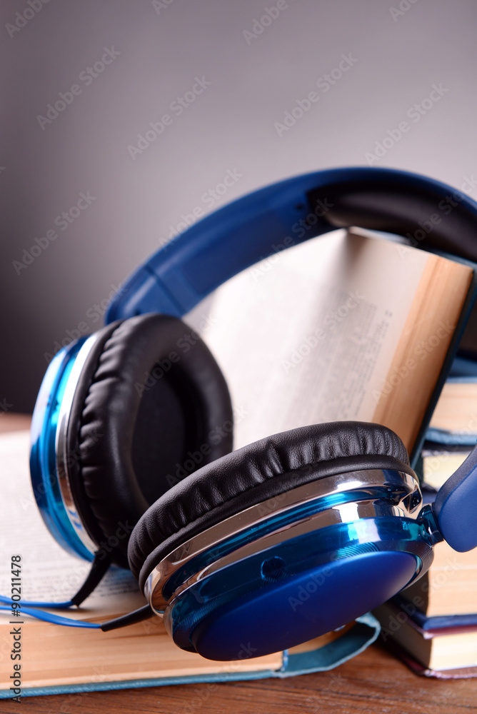 Books and headphones as audio books concept on grey background Books and headphones as audio books concept on grey background
