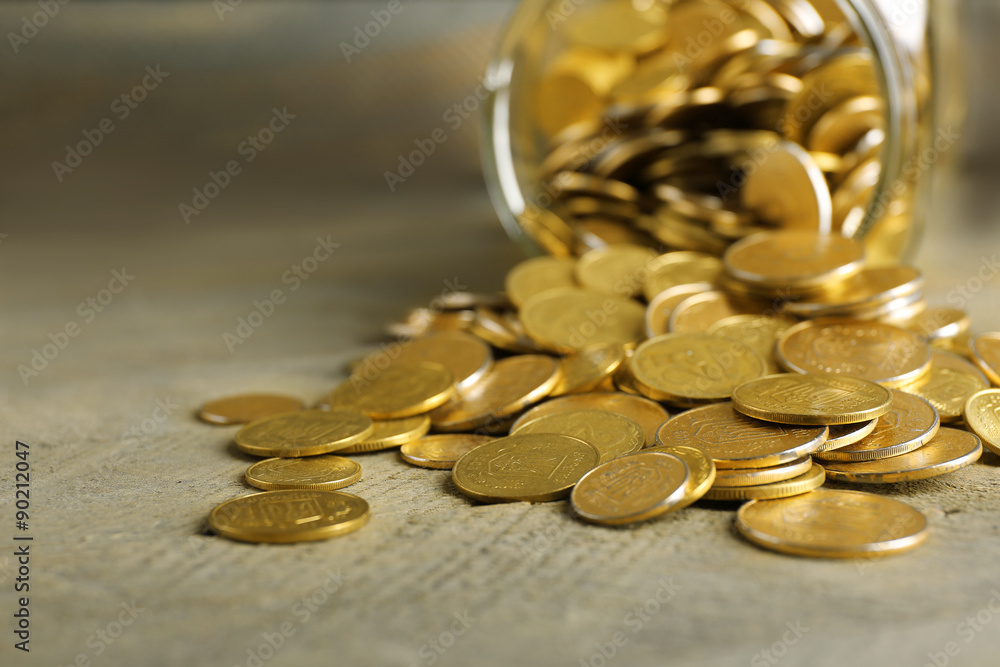 Glass jar with coins on wooden background Glass jar with coins on wooden background
