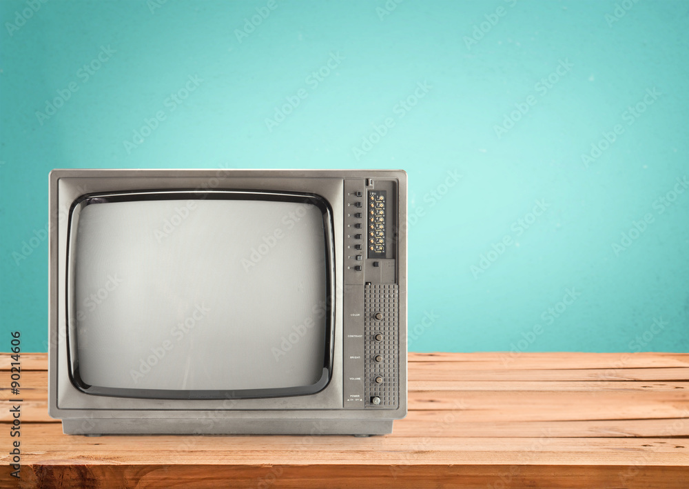 Retro Television on wood table with vintage aquamarine wall background