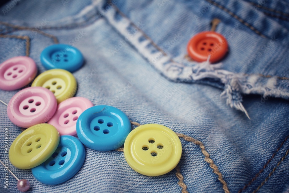 Colorful sewing buttons on jeans Colorful sewing buttons on jeans