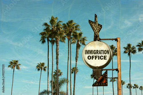 aged and worn vintage photo of immigration office sign with palm trees