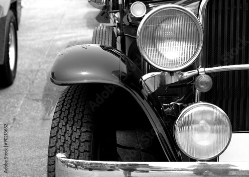 Retro headlight lamp vintage classic car parked in old city street  ,black and white style