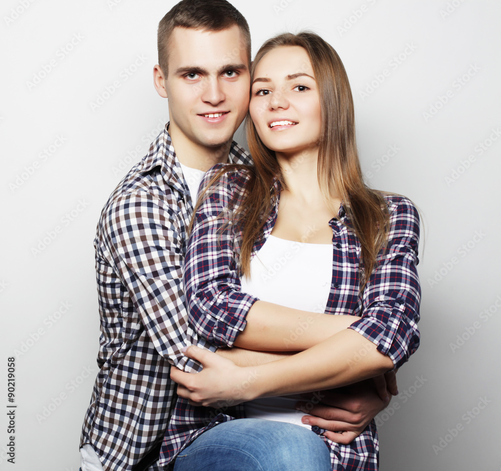 lovely happy couple hugging over grey background. lovely happy couple hugging over grey background.